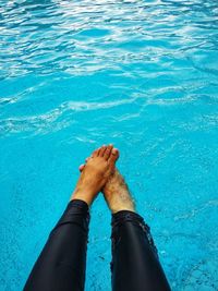 Low section of person swimming in pool