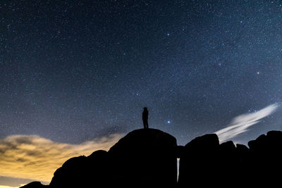 Low angle view of silhouette mountain against sky at night