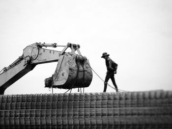 Low angle view of worker working against clear sky