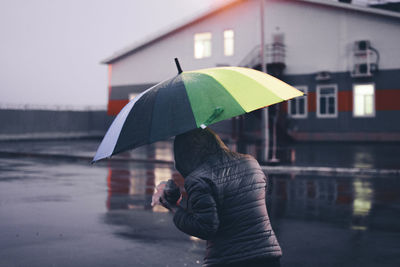 Man holding umbrella standing in rain