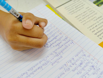 Close-up of hand holding book with text