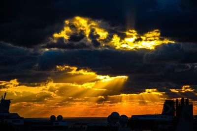 Silhouette city against sky during sunset