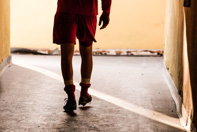 Low section of sportsman walking in corridor