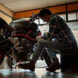 Mechanic repairing motorcycle at garage