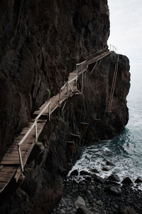 Bridge over sea against rock formation