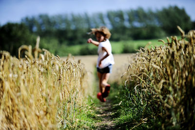 Girl running through wheat field