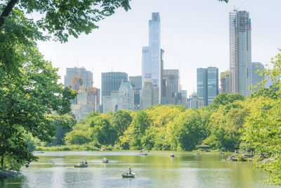 Scenic view of river by buildings against sky