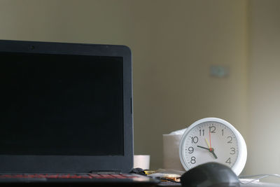 Close-up of clock on table at home