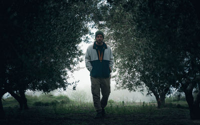 Portrait of young man walking in forest