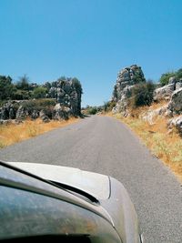 Car on road against clear blue sky