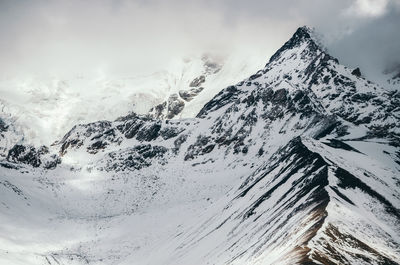 Low angle view of snow on mountain against sky