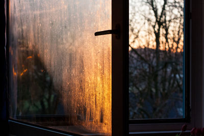 Close-up of window against sky at sunset