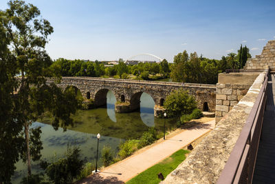 Arch bridge over river against sky