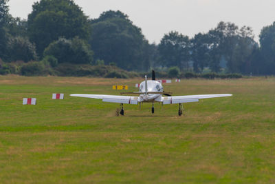 Airplane on field against sky