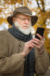 Midsection of man using mobile phone outdoors