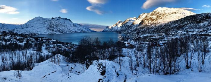 Scenic view of snow covered mountains against blue sky