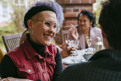 Portrait of smiling friends sitting at home