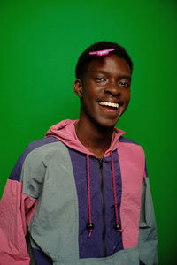 Portrait of young man standing against blue background