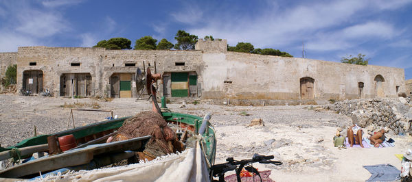 Tourists at beach against sky