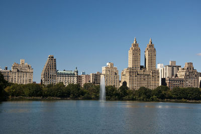 City at waterfront against clear sky