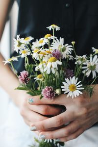 Close-up of hand holding bunch of flowers