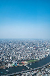 High angle view of buildings in city against blue sky