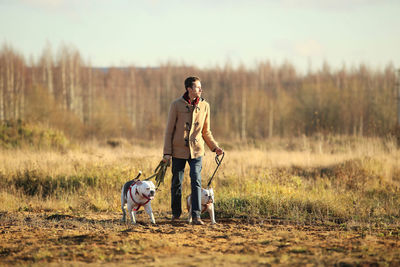 Full length of woman with dog on field