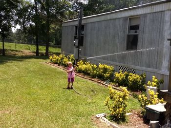 Full length of woman with umbrella against plants