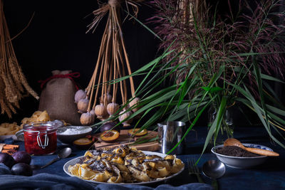 Sweet pasta dessert, noodles with poppy seeds, close-up of the food on table with dark background.