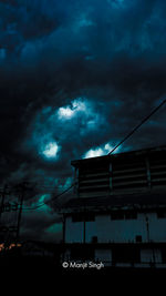 Low angle view of silhouette building against sky at night