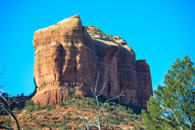 Low angle view of rock formation against clear blue sky