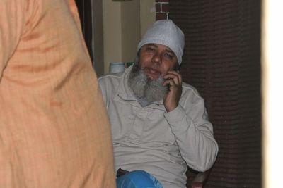 Midsection of man sitting in hat