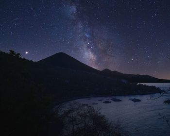 Scenic view of lake against sky at night