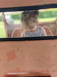Portrait of girl looking through window