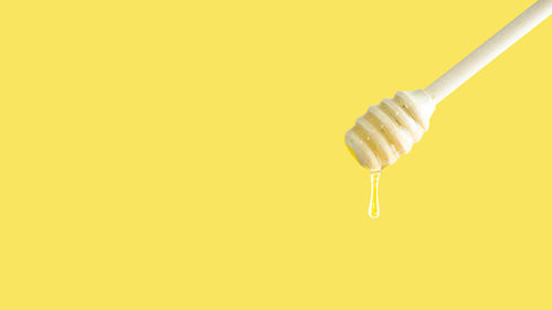 Close-up of toothbrush against yellow background