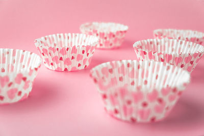 Close-up of cupcakes on table against pink background