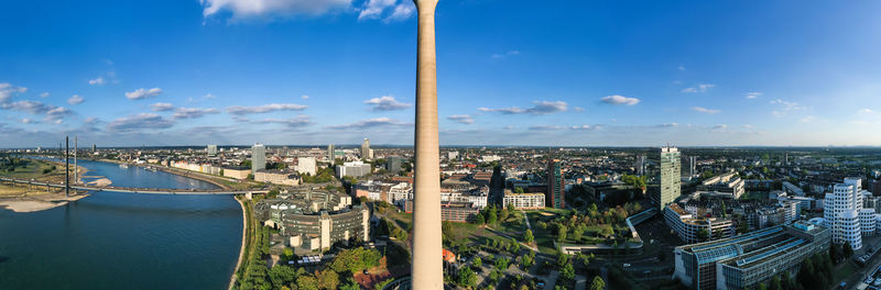High angle view of city buildings against cloudy sky