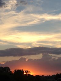 Scenic view of dramatic sky over city during sunset