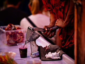 Cropped hand of man preparing grenade juice