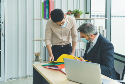 Rear view of men working in office