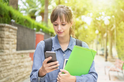 Focused young female student checking her phone