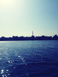 Scenic view of sea by buildings against clear sky