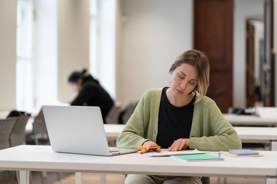 Focused middle-aged woman student prepare for coursework in university high school or college campus