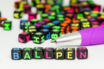 Close-up of colorful text and pen on table