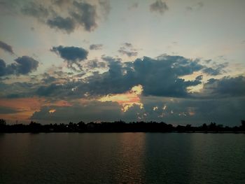 Scenic view of sea against cloudy sky during sunset