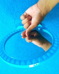 Close-up of hand holding blue pool