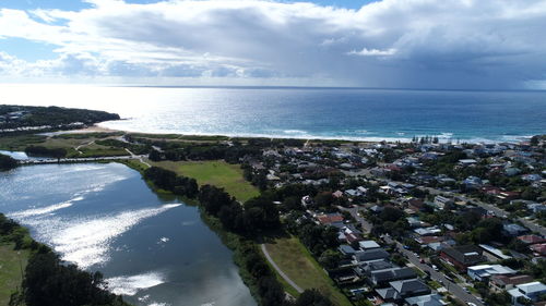 High angle view of townscape by sea against sky