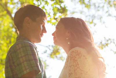 Side view of couple kissing against blurred background