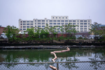Reflection of building in lake against clear sky