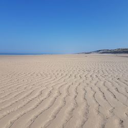Scenic view of sandy beach against clear sky